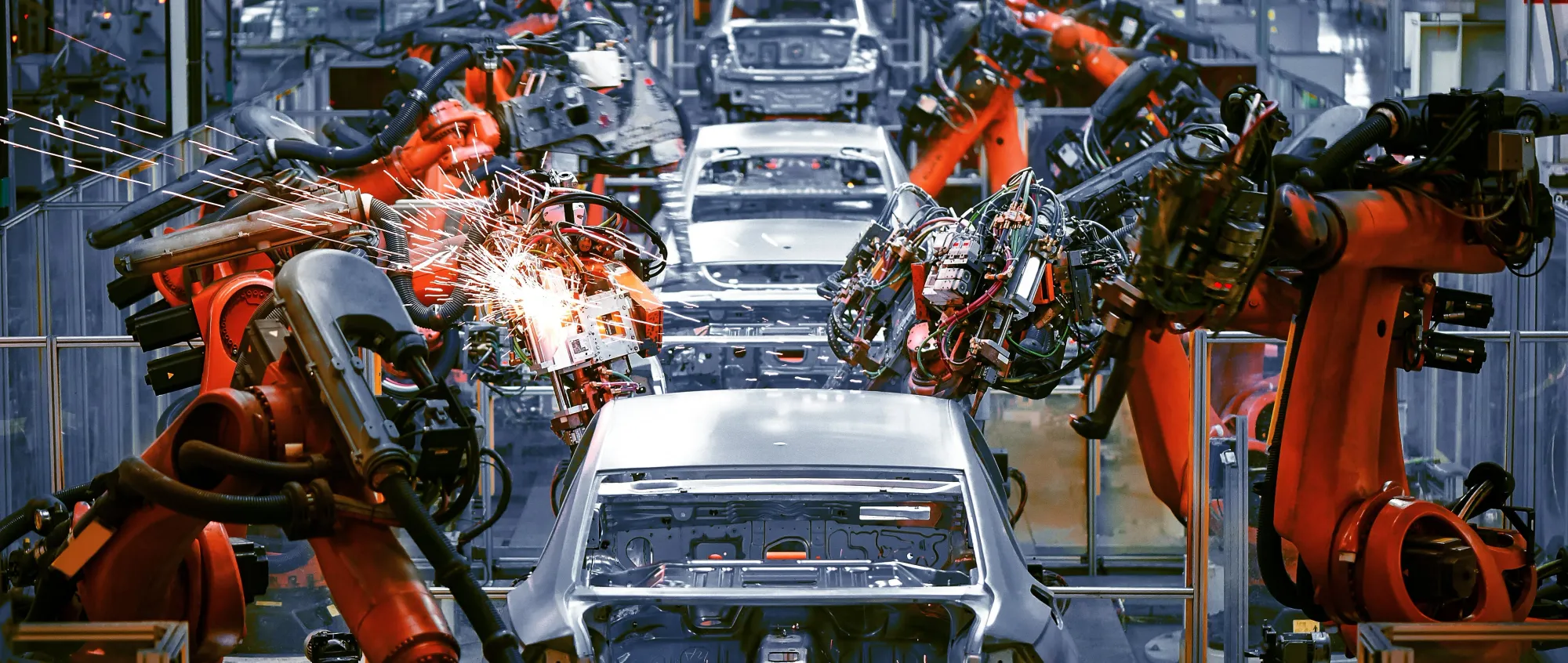 Robotic arms welding car frames in an automotive assembly line